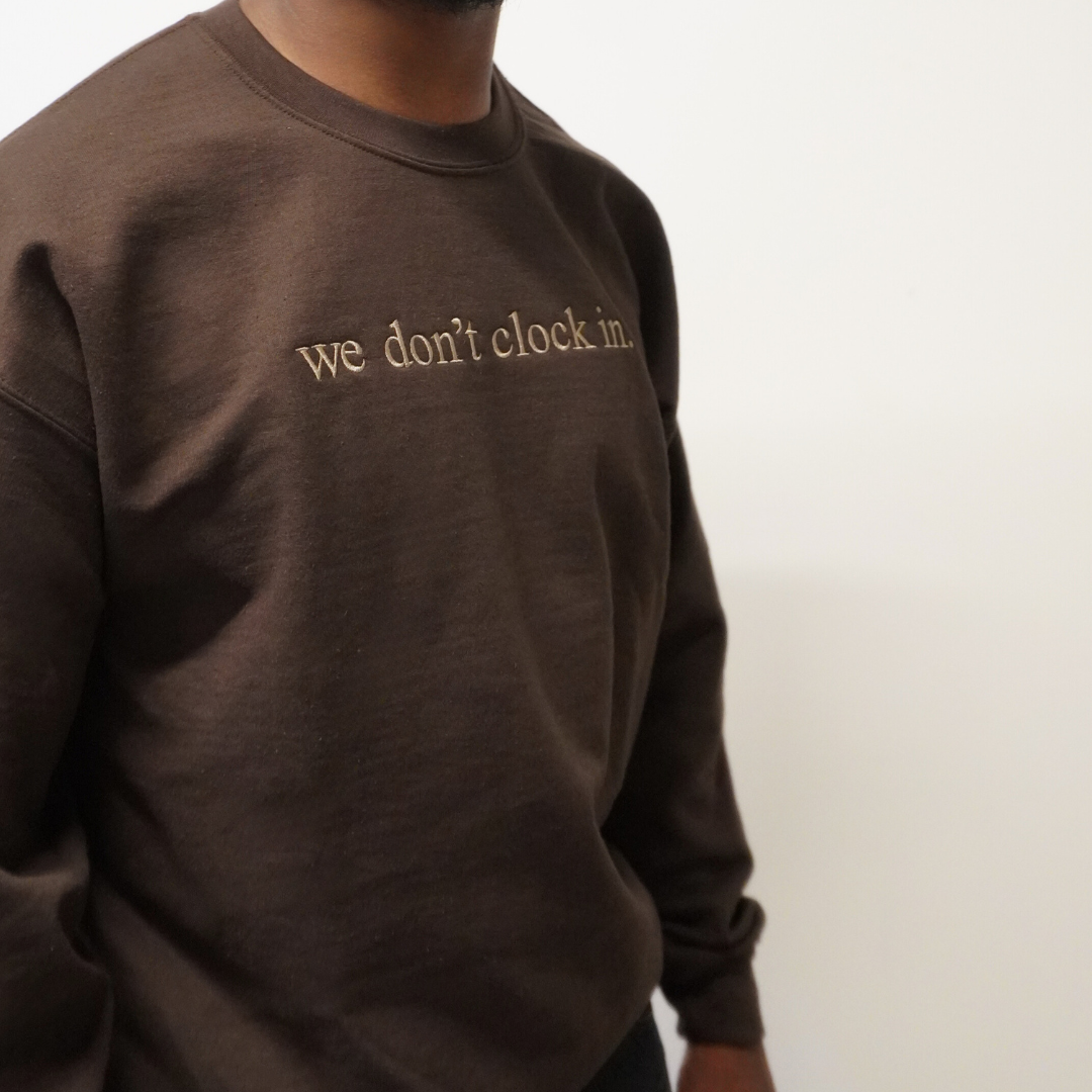 Our "we don't clock in." brown crewneck is made from.... This comfortable and stylish crewneck has been crafted for repeat wear and reflects the intersection of timeless fashion and durability. Crafted with care and precision, its minimalist design allows the powerful statement "we don't clock in." to take center stage, making it a conversation starter wherever you go. Wear with pride, knowing that you're not just wearing a garment, but a symbol of independence and self-determination.