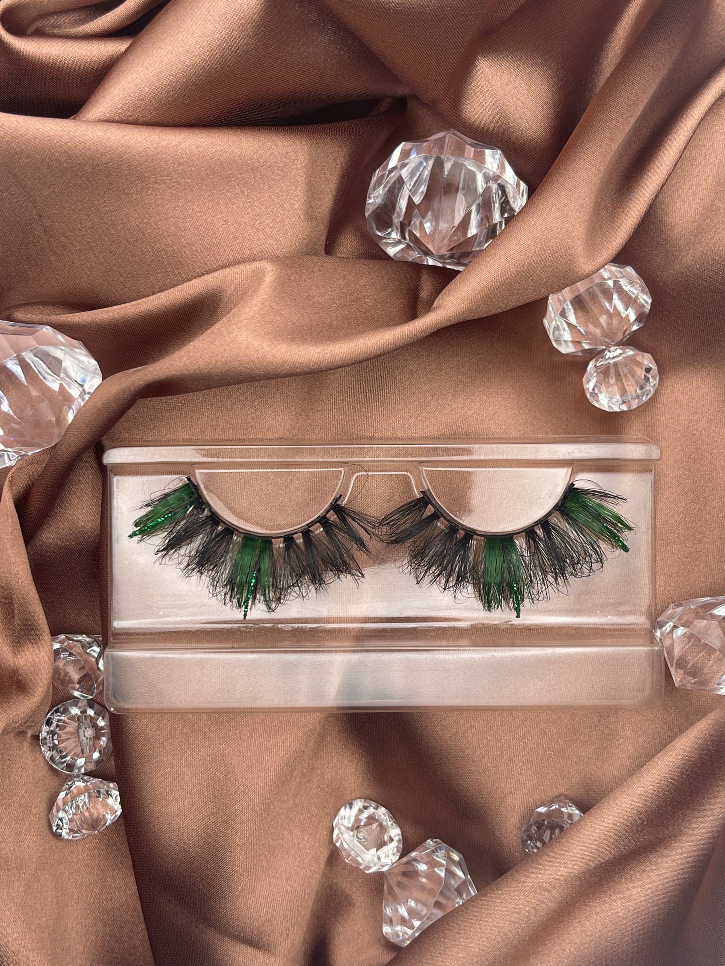 With a hint of green glitter, these 23mm Teirrah Seinek Grandoise luxury lashes are bound to complete your outfit. These lashes add length, volume, and thickness to your lash look, and are undetectable, blending with your natural lash line.  Lash Length: 23mm Full Strip Lashes